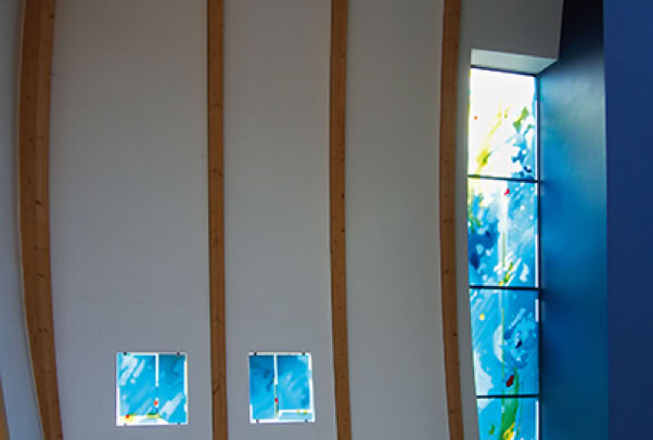 Gemeindezentrum Ev. Luth. Kirche, Hamburg-Hoisbüttel. Fenstergestaltung. Vierschichtige Glascollage, Zuschnitt aus Echt-Antiküberfanggläsern, mehrfach geätzt, partielle Malerei mit Glasschmelzfarbe, flächig auf Sicherheitsglas laminiert und als zusätzliche innere Scheibe montiert.